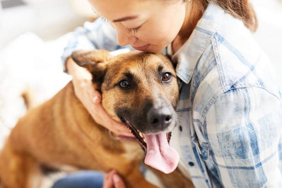 A woman hugs her dog