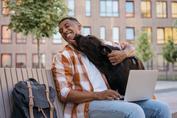 A dog licks a man's face while the man holds him