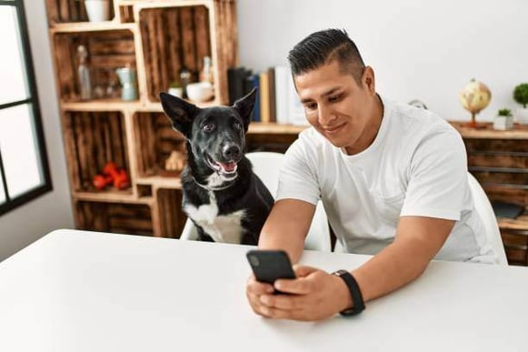 A man takes a photo with a dog