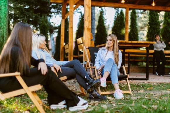 A group of people sit in chairs outside