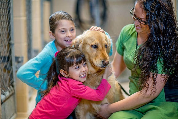 Two kids hug a dog